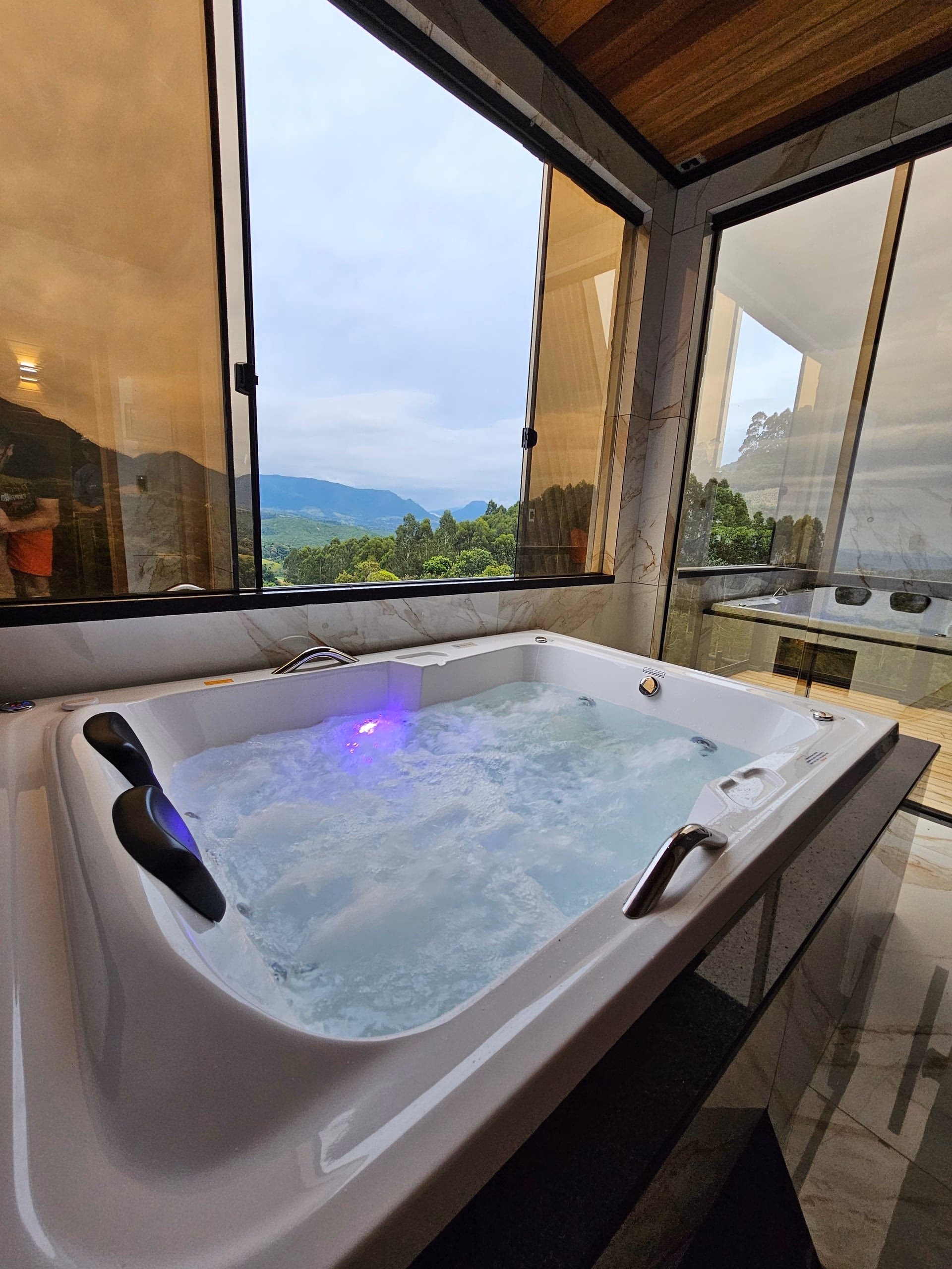 Banheira de hidromassagem com iluminação azul, em ambiente intimista
