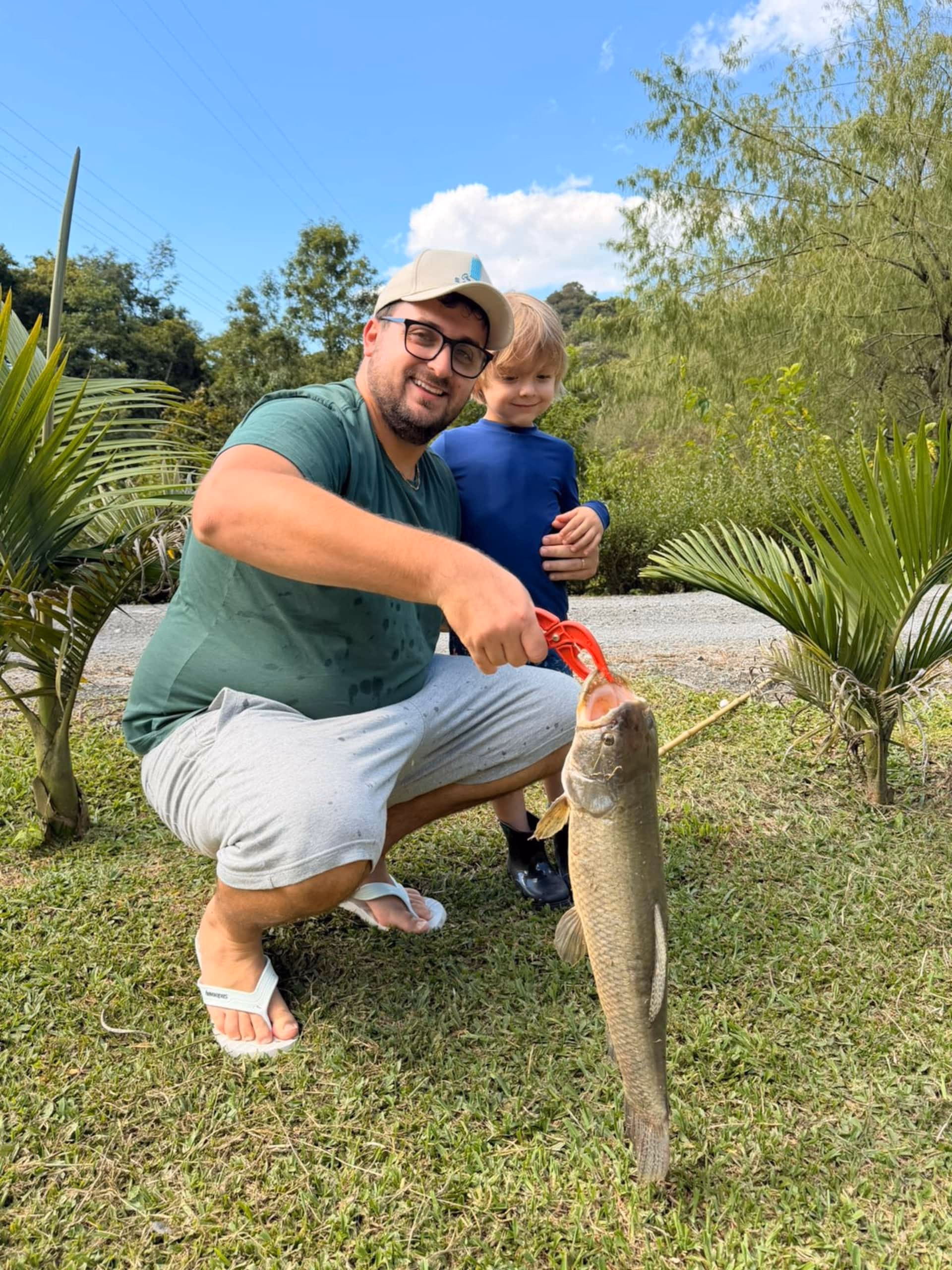 Hóspede segurando um peixe pescado no lago da propriedade