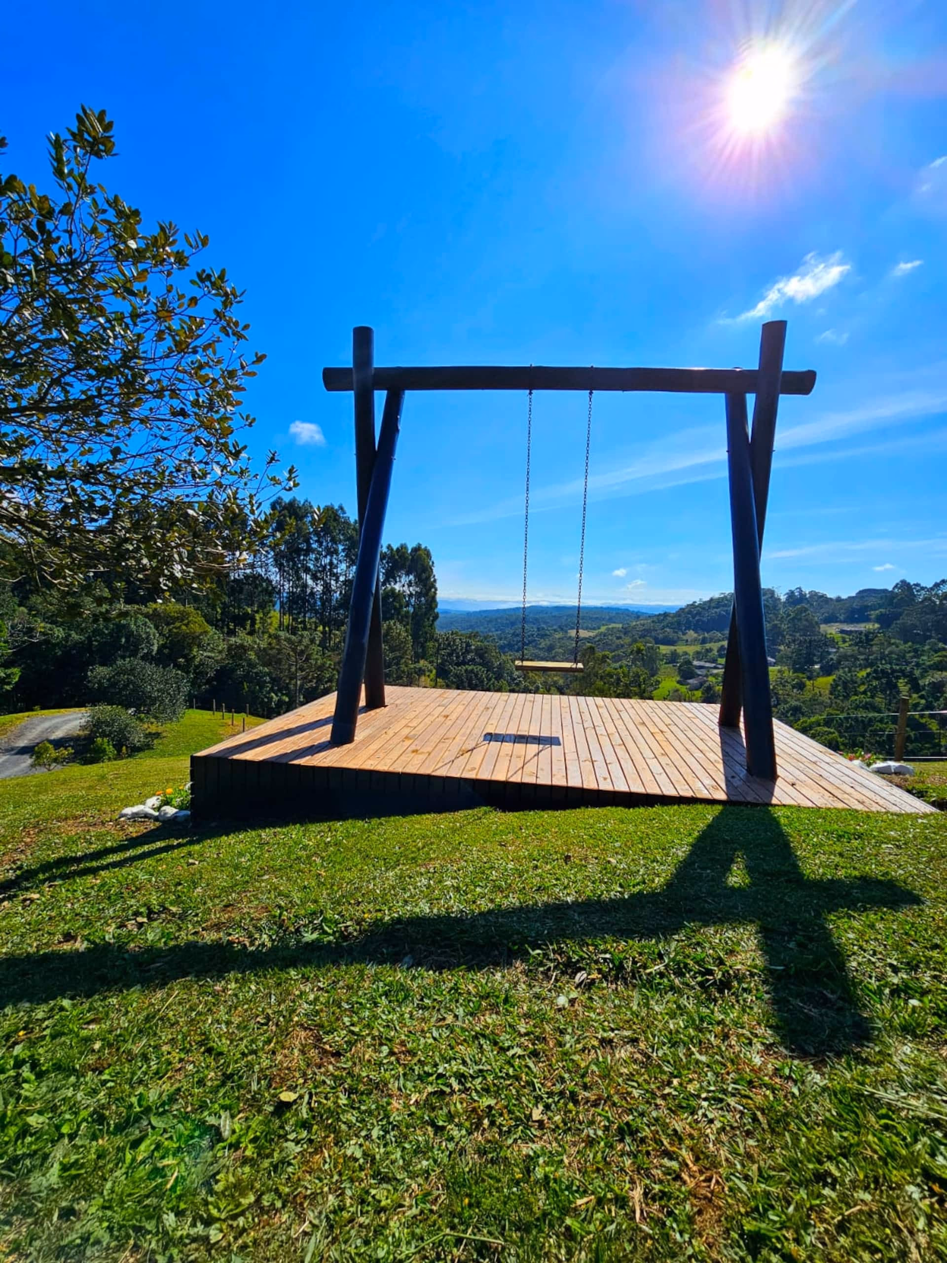 Balanço de madeira no jardim do chalé sob céu azul de dia