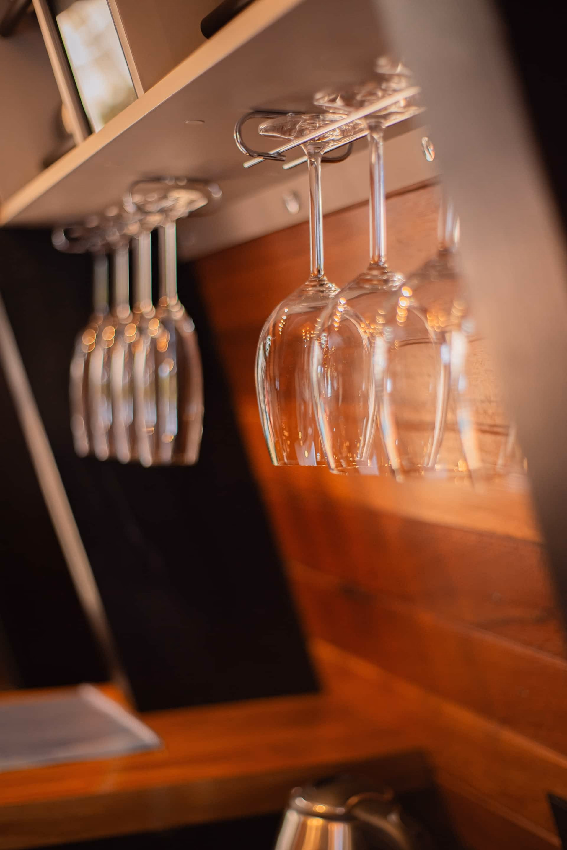 Taças de vinho penduradas junto à parede de madeira