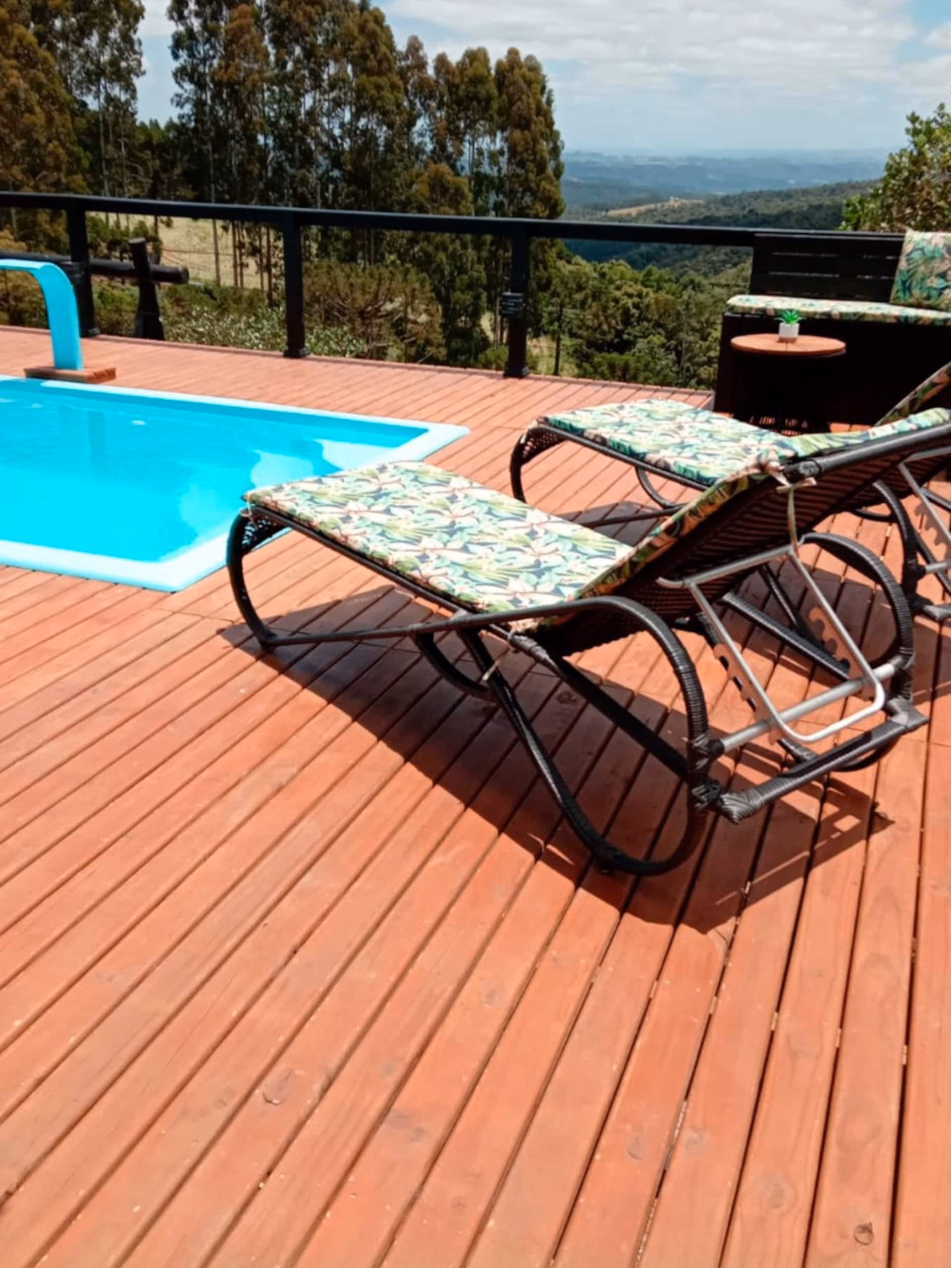 Espreguiçadeiras de frente para a piscina, com vista para as montanhas